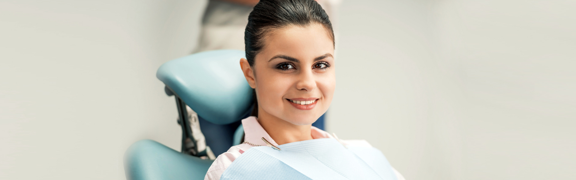 Portrait of mid adult brunette female patient smiling in dentistry.